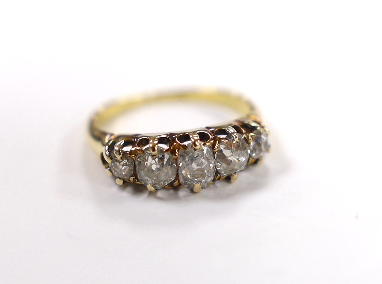 A yellow metal and graduated five stone diamond set half hoop ring, size J, gross weight 3.5 grams (a.f.).